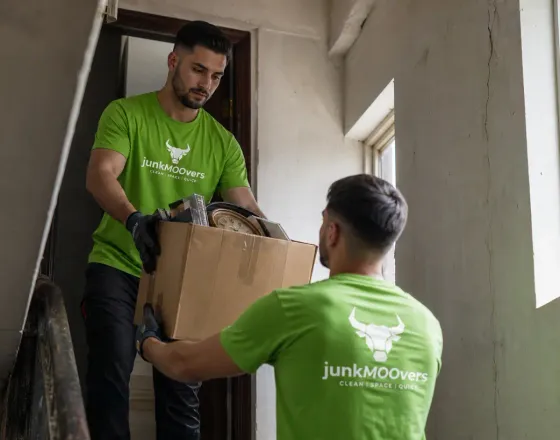 Two junkMOOvers team members carrying furniture in Chicago